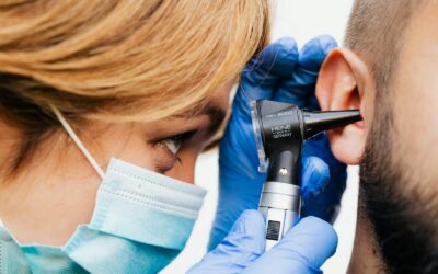 Gros plan d'un médecin effectuant un examen de l'oreille avec un otoscope.