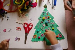 un enfant fabrique un sapin de Noël en feutre